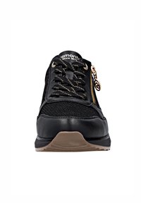 Sneaker nera con tomaia in rete, cerniera con dettagli dorati, lacci testurizzati e suola in gomma marrone. Design con punta arrotondata e tacco piatto.