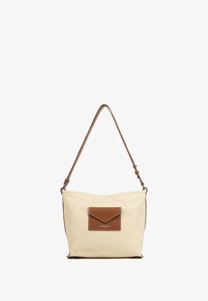 Borsa a spalla in tela beige con una tasca in pelle marrone e tracolla. Texture morbida, forma curvata e dettagli di cucitura presenti.