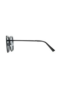 Black glasses featuring oversized, round frames with a glossy finish and thin metal arms, designed for a minimalist appearance.