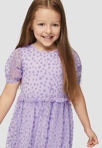 Lavendelfarbenes Kleid mit Puffärmeln, das über eine gepunktete Textur und einen rüschierten Taillenbund verfügt. Leichtes, semi-transparentes Material. Kinderfreundliches Design.