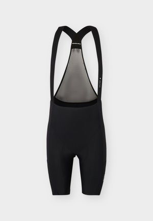 Cuissards de cyclisme noirs avec bretelles croisées dans le dos et un panneau intérieur gris, conçus pour la performance et le confort.