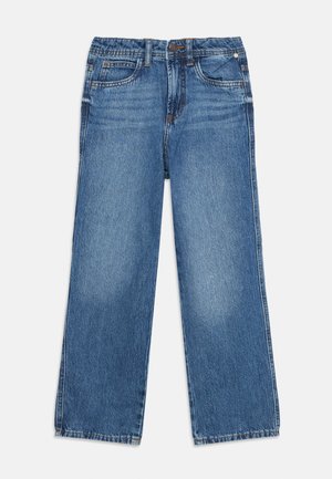Niebieskie jeansy z denimu z elastycznym pasem, pięcioma kieszeniami, zapięciem na guzik i zamek błyskawiczny, wyłożone na płasko na białym tle.