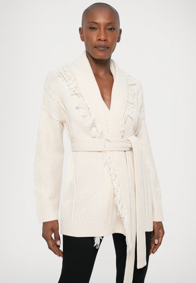 Cardigã de malha em off-white com gola de xale, detalhes de franjas e um cinto de laço. Apresenta um padrão texturizado e mangas longas.