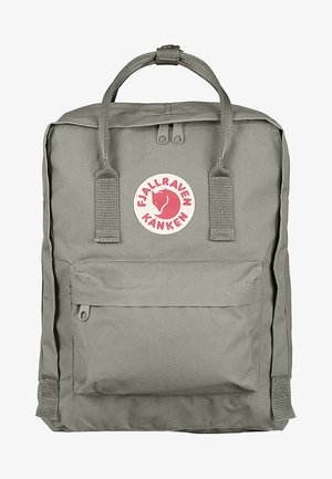 Gray backpack with a rectangular shape, made of durable fabric. Features a front pocket, two top handles, and a circular logo in red and white.