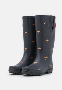 Bottes de pluie en caoutchouc navy avec un motif d'ombrelle orange, dotées d'une semelle texturée et d'un détail de sangle latérale pour un ajustement.
