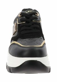 Sneaker nera e oro con un design testurizzato, punta rotonda, lacci davanti e una suola bianca spessa con una curva leggera.