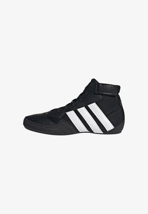 Scarpa sportiva nera alta con tre strisce bianche sul lato, chiusura frontale con lacci e aree traforate sulla punta e alla caviglia.