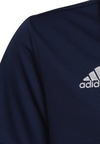 Marineblaue Sportshirt mit glatter Textur und kurzen Ärmeln, ausgestattet mit einem weißen Adidas-Logo auf der linken Brustseite.