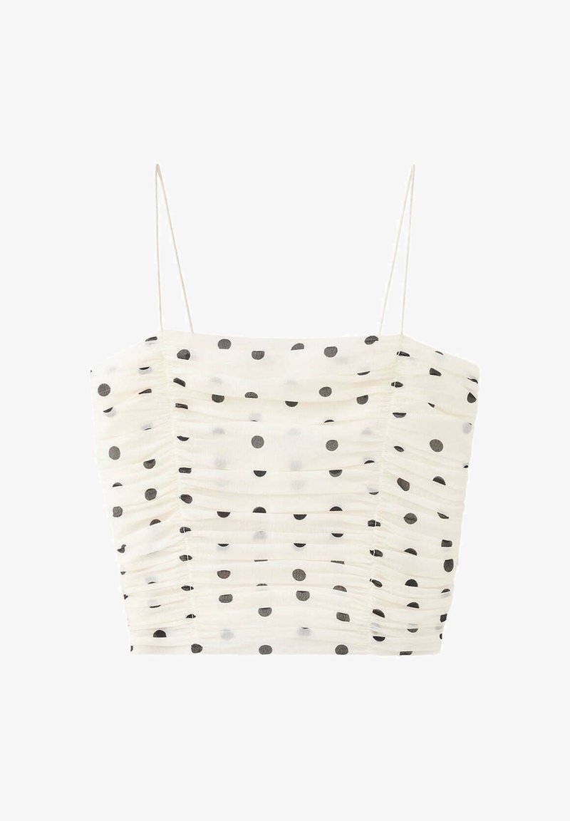 Crop top blanc froncé avec fines bretelles et motif à pois noirs répartis uniformément sur le tissu.