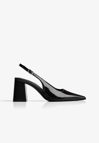 Musta patentoitu nahka slingback-kengät, joissa on terävä kärki ja neliömäinen korko. Varusteena on säädettävä hihna ja leikattu sivusuunnittelu.