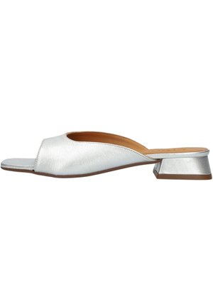 Zilveren mule-sandaal met open teen, lage blokhak en beige binnenvoering, zijaanzicht op witte achtergrond.