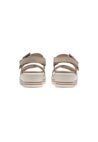 Beige sandals with two adjustable straps, a cushioned footbed, and a white sole featuring brown detailing. Back view shows a flat design.