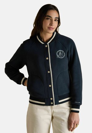 Navy fleece jacket with white accents, ribbed cuffs, and a logo on the chest. Features buttons and side pockets. Smooth texture.