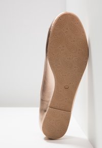 Ballerines avec une tige en cuir lisse couleur marron clair et une semelle en caoutchouc texturée arborant un motif cachemire, taille 37.