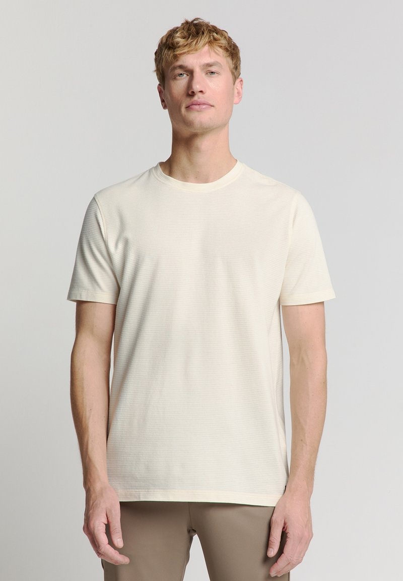 Korte mouwen, ronde hals t-shirt in lichtcrème, met een subtiele ribbelstructuur en een ontspannen pasvorm. Glad materiaal met een rechte zoom.