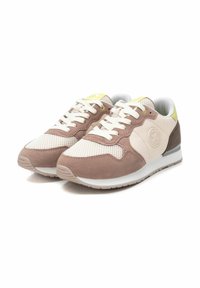 Zapatillas marrones y crema con texturas de malla y ante, con cordones blancos, un acento amarillo en la lengüeta y un logo circular.