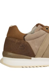 Zapatillas de ante marrón y malla con un diseño texturizado, que cuentan con una suela beige contrastante y costuras de acento cerca del cuello.