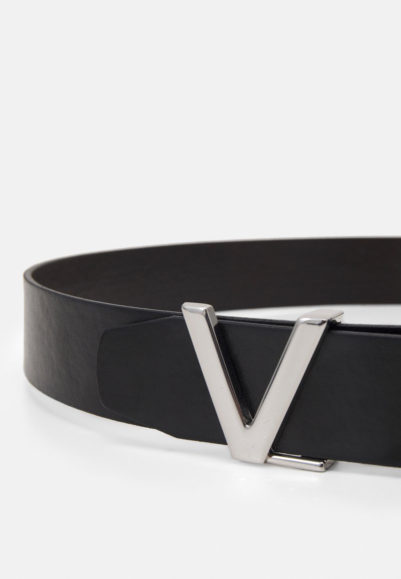 Cinturón de cuero negro con una hebilla de metal plateada pulida con un diseño en forma de V. Textura suave y diseño minimalista.