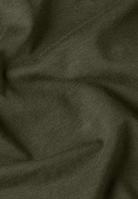 Gros plan sur un tissu tricoté vert foncé avec une texture visible et des plis doux.