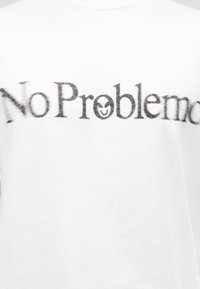 Λευκό μπλουζάκι με θολό μαύρο κείμενο «No Problem» και ένα χαμογελαστό πρόσωπο που αντικαθιστά το γράμμα «ο» στην λέξη «Problem» μπροστά.