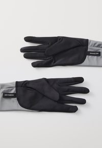 Sorte og grå Nike løbehandsker, der har et glat, strækbart materiale, tætsiddende design og en struktureret fingerspids til brug med touchscreen.