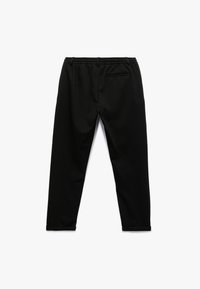 Schwarze Jogginghosen aus weichem Stoff, mit einem Kordelzugbund und einer dezenten Gesäßtasche. Schmal zulaufendes Bein-Design mit Bündchen.