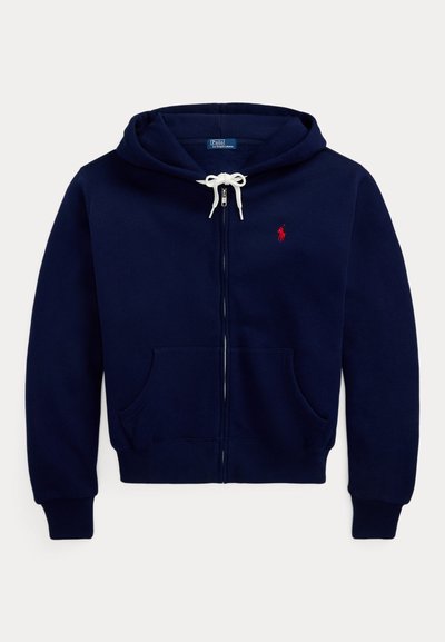 Μπλε σκούρο φούτερ με φερμουάρ, λευκά κορδόνια, τσέπες μπροστά, ριμπ μανσέτες και μικρό κόκκινο κεντητό λογότυπο στο στήθος.