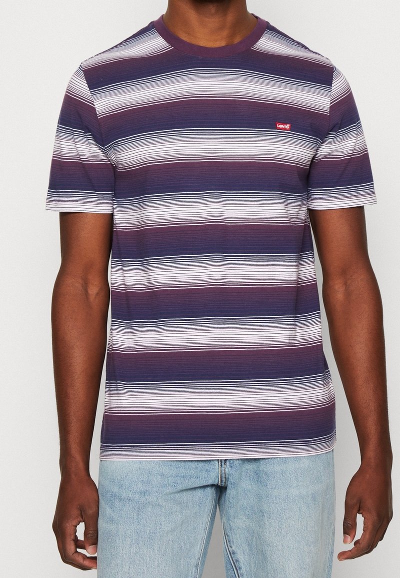 T-shirt à manches courtes rayé en bleu marine, blanc et bordeaux. Col rond, tissu doux, avec un petit logo Levi's rouge sur la poitrine.