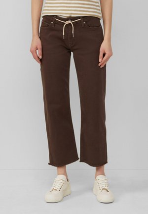 Bruine wijde-pijp broek met een trekkoord in de taille en een rafelige zoom, gecombineerd met witte sneakers. De textuur lijkt glad en katoenachtig.