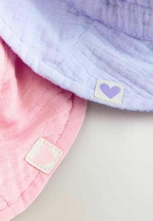 Duomenų iš minkšto medvilninio audinio siuvami du skrybėlės, viena levandų spalvos, o kita rausva, kiekviena su mažu etikete su širdies dizainu šone.