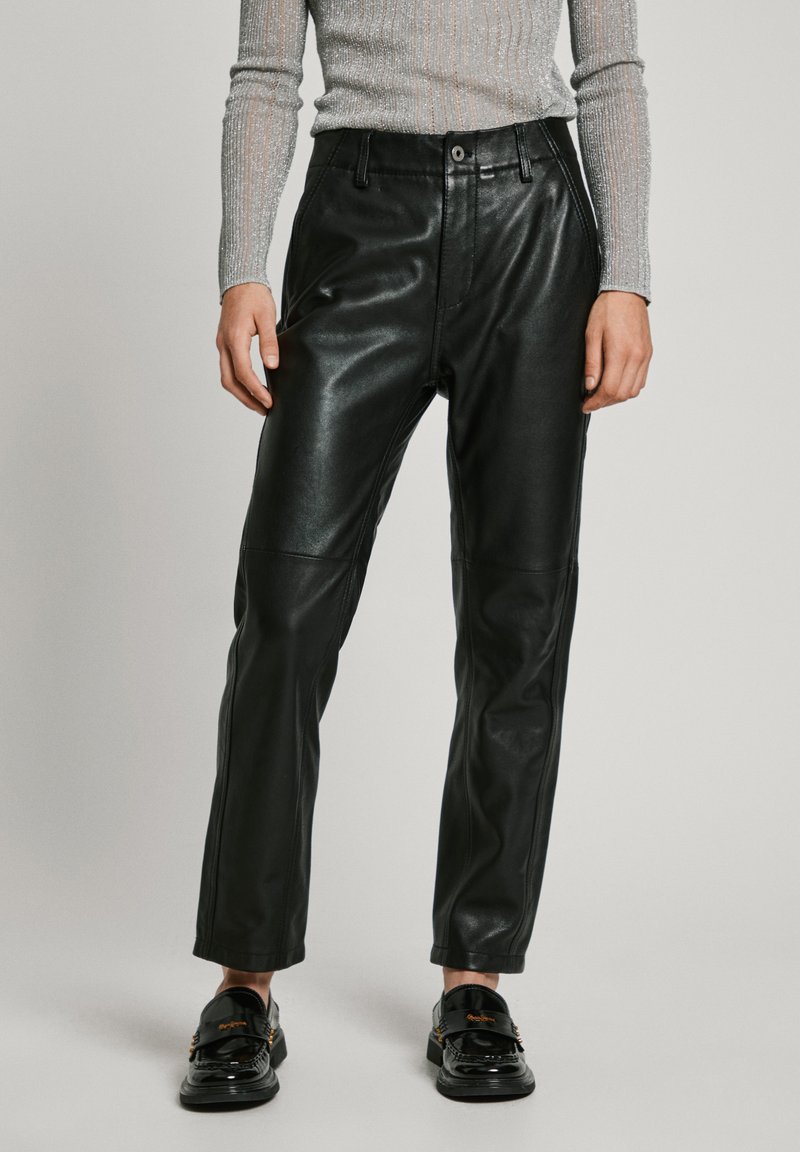 Black leather pants with a straight cut, featuring front pockets and a smooth texture, worn with shiny black loafers.