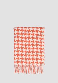 Koc w pomarańczowo-białą kratę, z wzorem houndstooth, frędzlami na brzegach, miękką teksturą i prostokątnym kształtem.