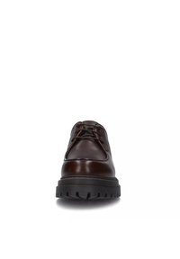 Zapato de cuero marrón con cordones, punta redonda, detalles de costura y una suela gruesa de goma negra con un patrón de relieve.