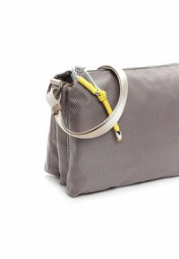 Borsa grigia texturizzata con una forma strutturata, dotata di una tracolla beige e di un accento giallo. Ha una chiusura con zip e hardware metallico.