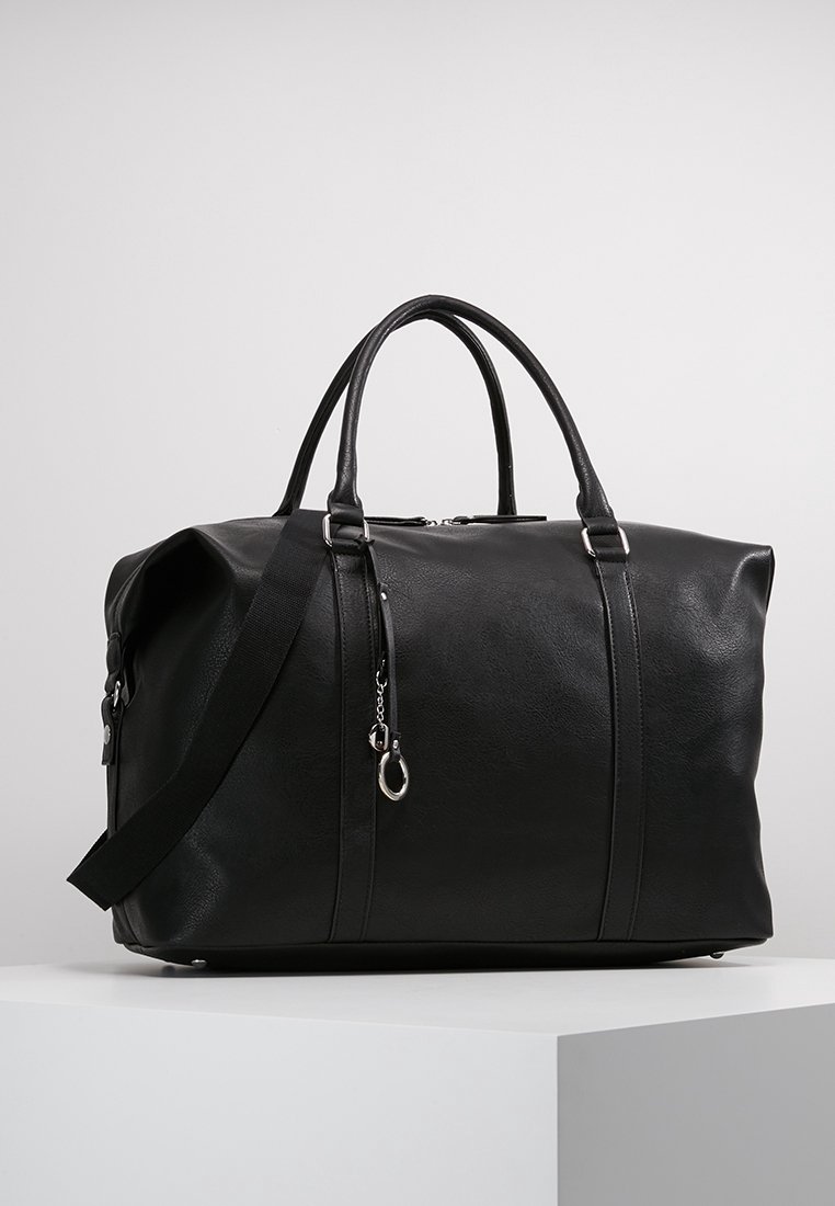 Sort faux læder duffel taske med buede håndtag og justerbar skulderrem, der har sølvfarvet hardware og en glat overflade.
