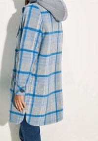 Grau karierter Mantel mit blauen Akzenten, grauer Kapuze und mit Knöpfen versehenen Manschetten. Weiche Wollmischung mit lockerem Schnitt und leicht gewelltem Saum.