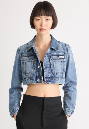 Giacca in denim tagliata in blu medio con due tasche anteriori, bottoni argentati e colletto a punta. Presenta una texture sbiadita e una vestibilità strutturata.