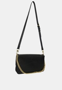 Sac bandoulière en cuir noir avec un accent chaîne dorée. Présente une forme rectangulaire et une sangle réglable. Surface texturée sans motifs visibles.