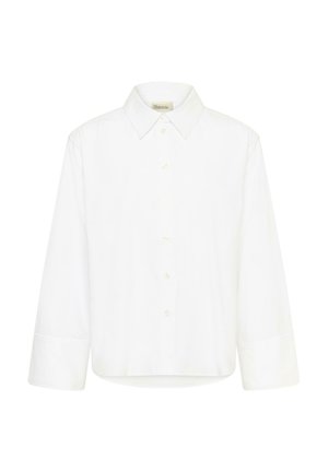 Witte blouse met lange mouwen, knoopjes en brede manchetten, met een puntige kraag, tegen een effen witte achtergrond.