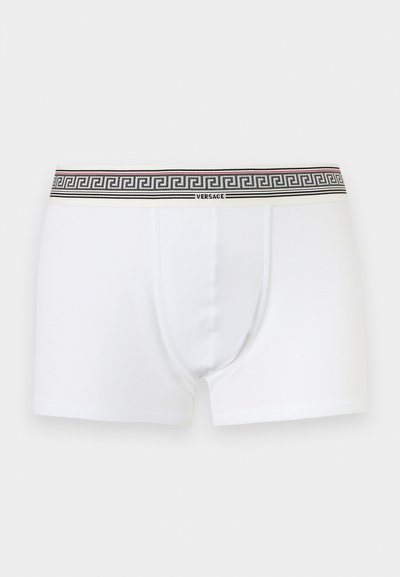 Boxers pour hommes blancs avec ceinture à motif noir et blanc arborant le logo Versace centré à l'avant.