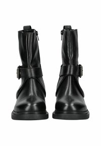 Botas de tobillo de cuero negro con un acabado suave, cremalleras laterales y una correa distintiva con una hebilla de metal en la parte frontal.