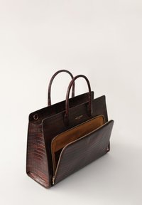 Brown crocodile-embossed leather handbag with dual handles, a front pocket, and gold-tone hardware, featuring a smooth texture and structured shape.