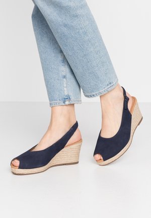 Granatowe sandały na koturnie ze skóry zamszowej, z odkrytym palcem i paskiem z tyłu, wyposażone w plecioną platformę z juty oraz teksturowaną gumową podeszwę.
