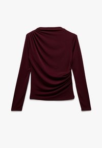 Langsleeve top in diep bordeaux stof, met een gedrapeerde achterkant en subtiele plooien. Soepele textuur en aansluitend ontwerp.