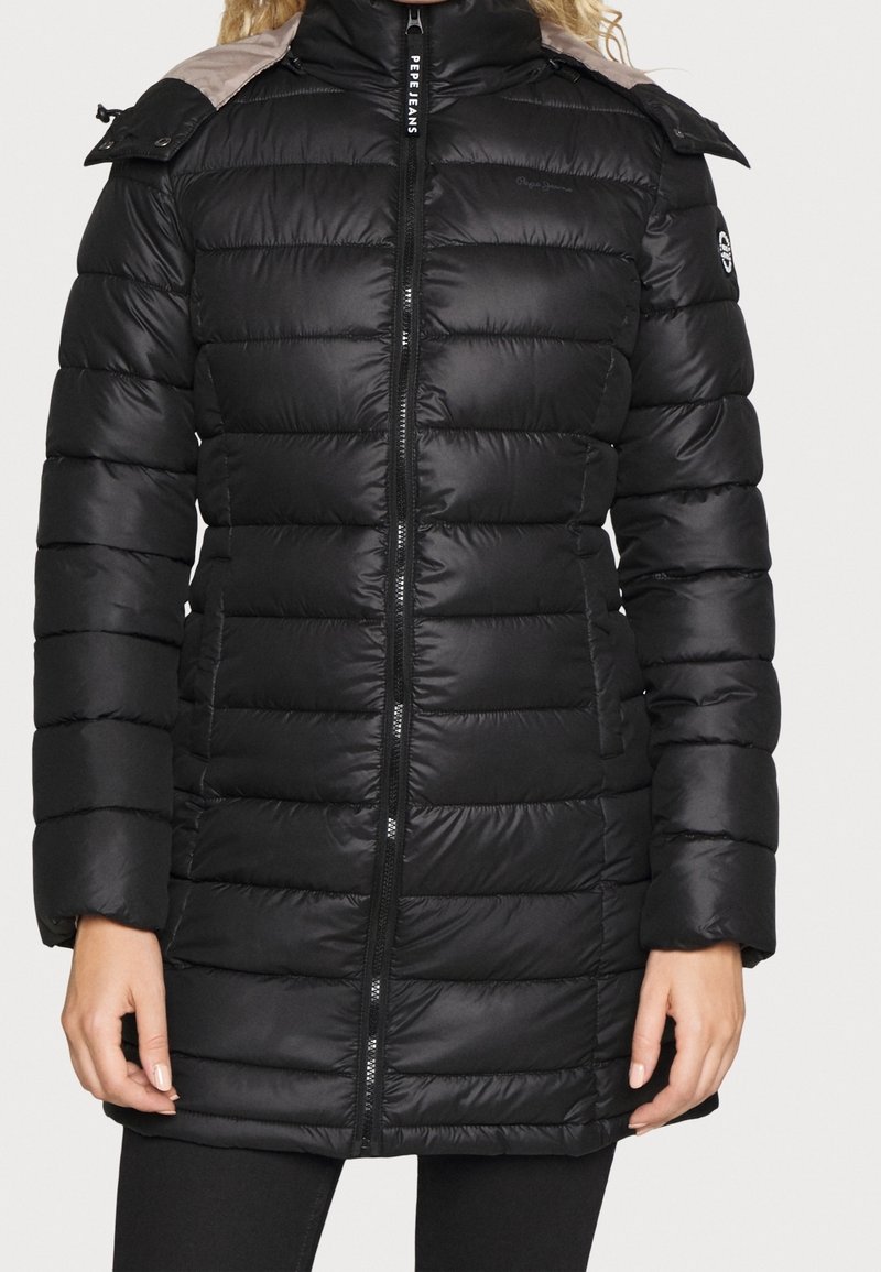 Černý péřový kabát s horizontálním prošíváním, vysokým límcem, předním zipem a šedými ramenními akcenty. Obsahuje logo na rukávu.