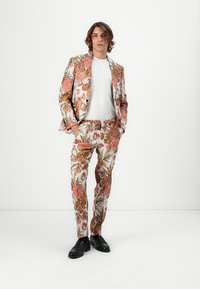 Blomstrete dress i kremfarge, med rosa og oransje blomster samt grønne blader. Utformet med en skreddersydd passform og spisse klaffer.