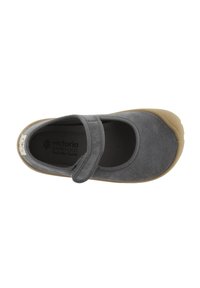 Zapato de ante gris con punta redonda y una correa de velcro. Suela de goma color marrón claro. Interior con forro de tejido texturizado.