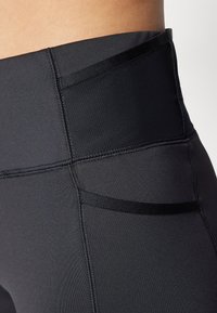 Höga svarta leggings gjorda av stretchigt material med en slät midja, platta sömmar och minimal detaljer för ett elegant utseende.