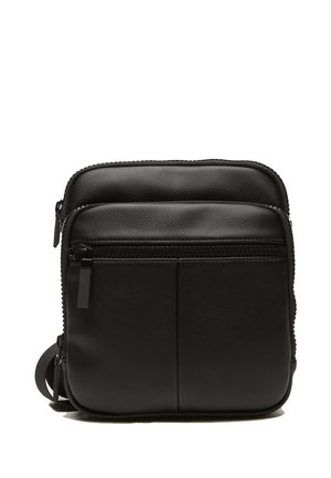 Black leather crossbody bag with dual zippered compartments, smooth texture, and adjustable strap. Minimalist design with no visible branding.
