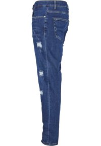 Mørkeblå denimjeans med slim fit, som har slitte detaljer og frayed lapper på forsiden, samt en standard midjebånd med løkker.